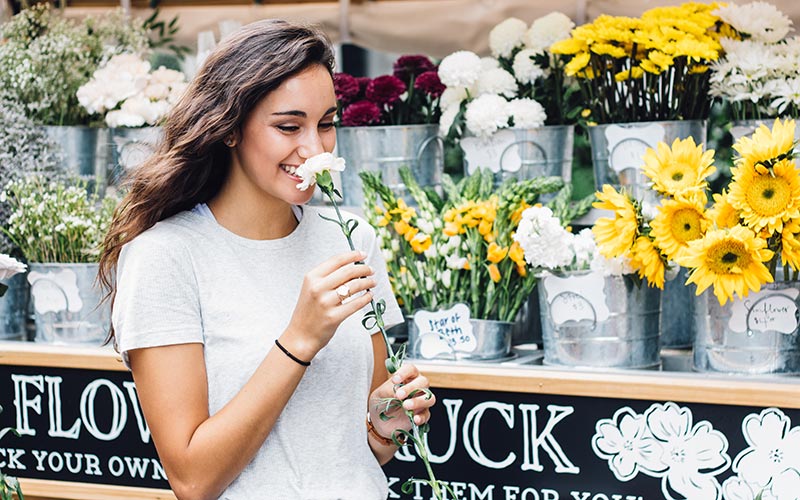 Mujer sonriendo con una flor