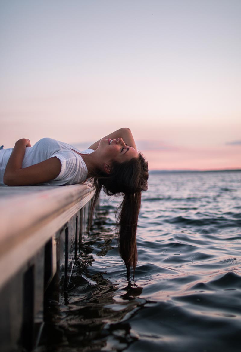 Mujer descansando a la orilla del mar