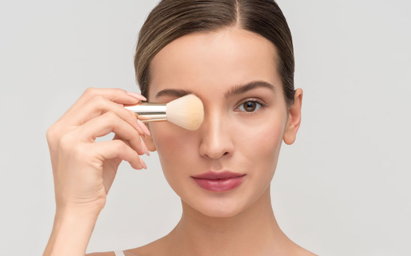 Mujer aplicando una base de maquillaje en el rostro