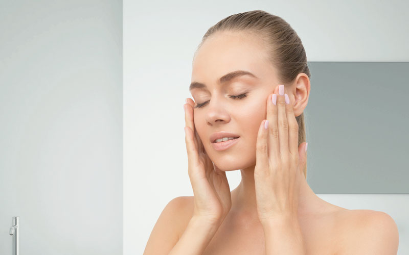 Mujer aplicando crema hidratante en la cara