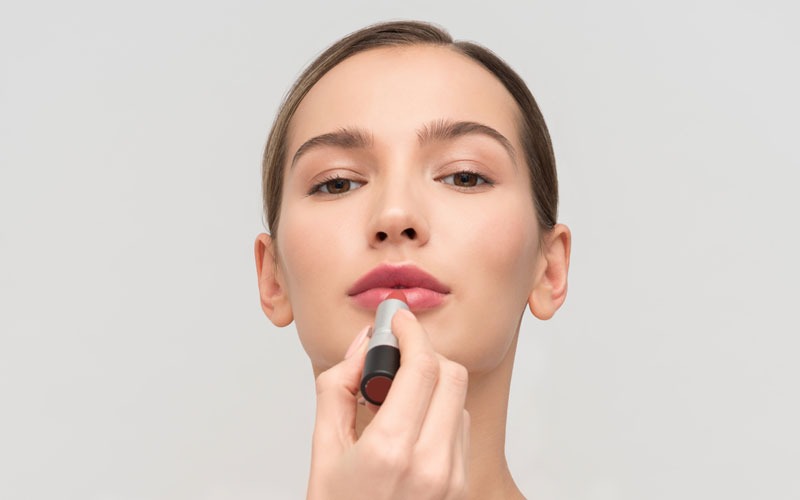 Mujer poniéndose pintalabios